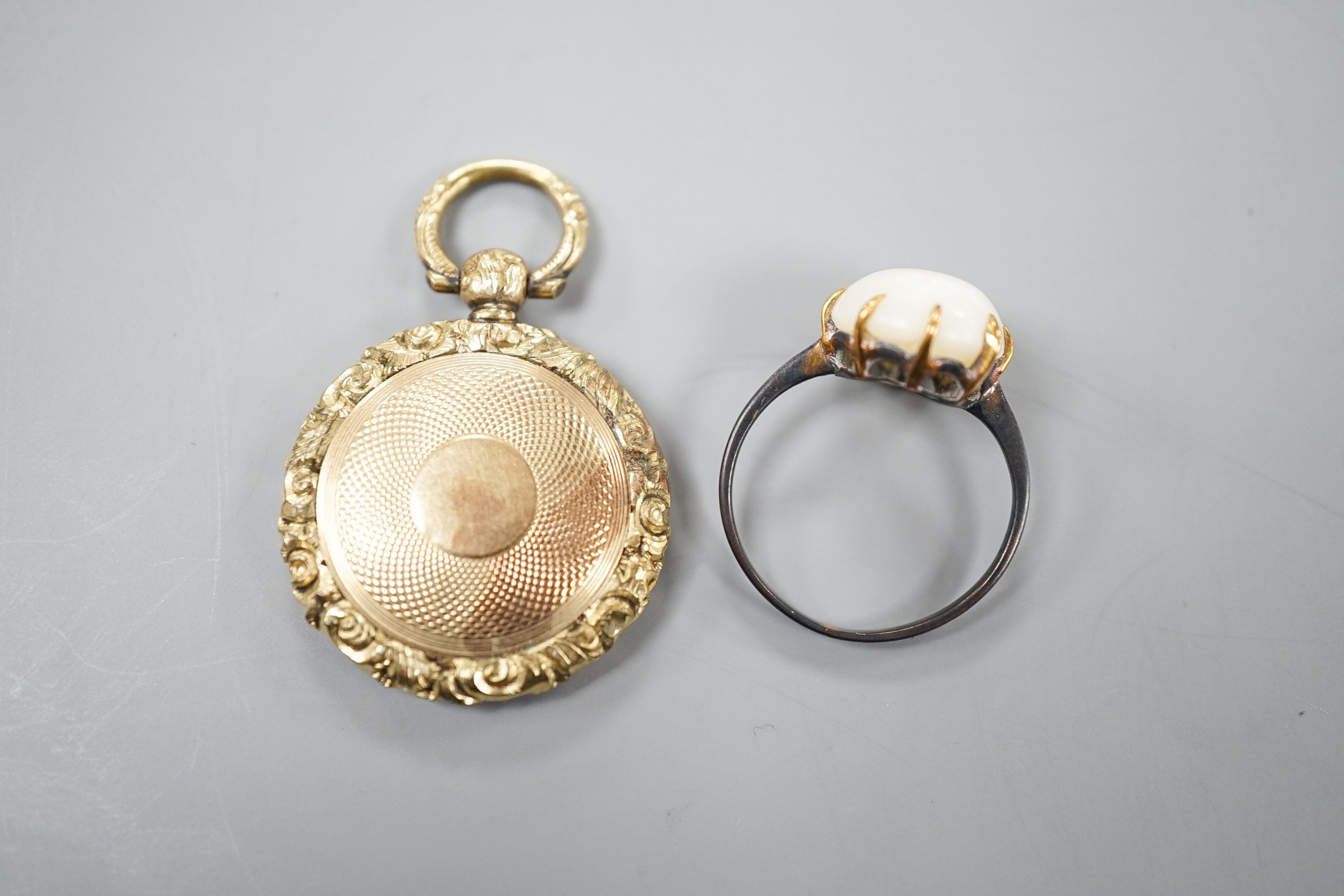 A yellow metal and white opal ring, size K/L and a late Victorian engraved yellow metal pendant, 25mm.
